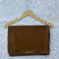 Brown fabric on a hanger with 'almond' label on a textured white background
