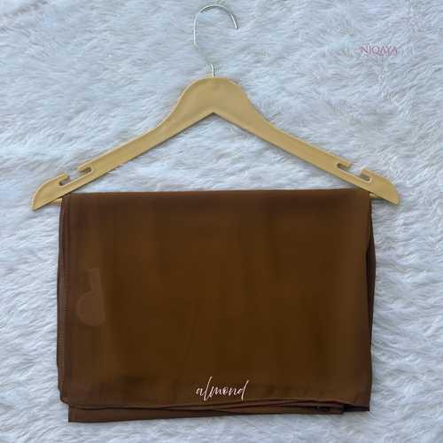 Brown fabric on a hanger with 'almond' label on a textured white background