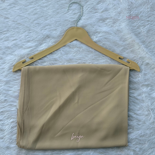 Beige fabric on a hanger with 'beige' label on a textured gray background