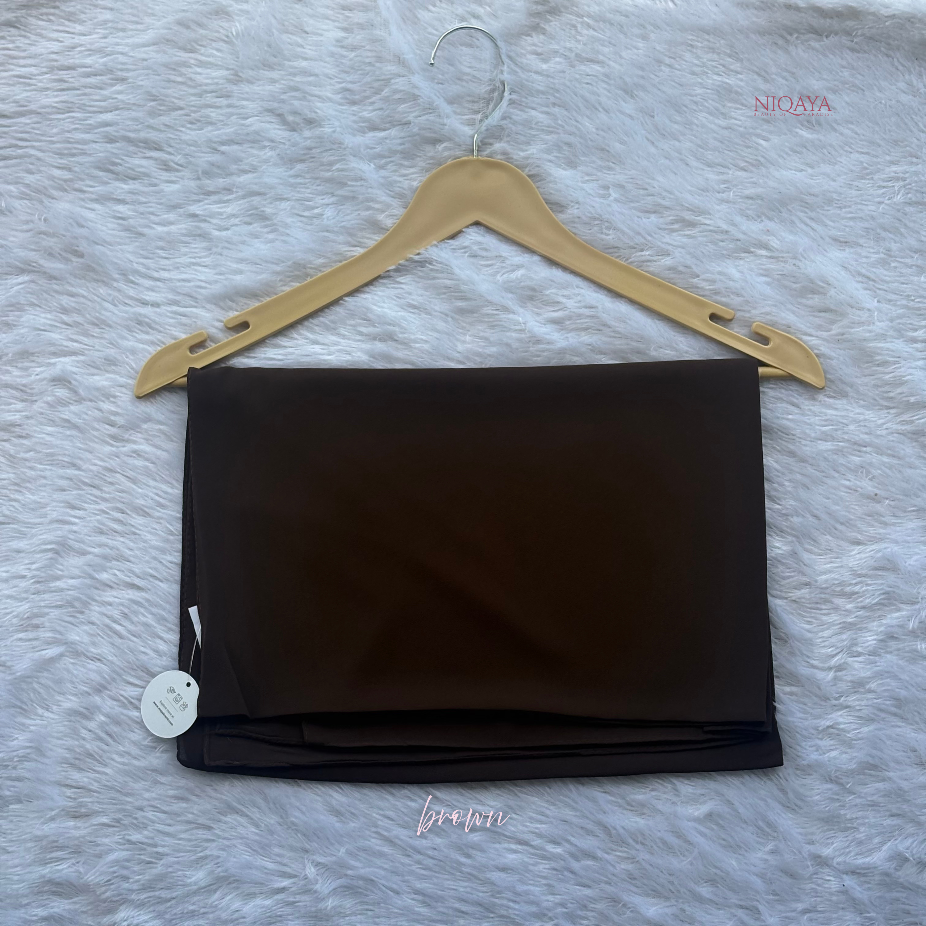 Black fabric on a hanger with a gray textured background