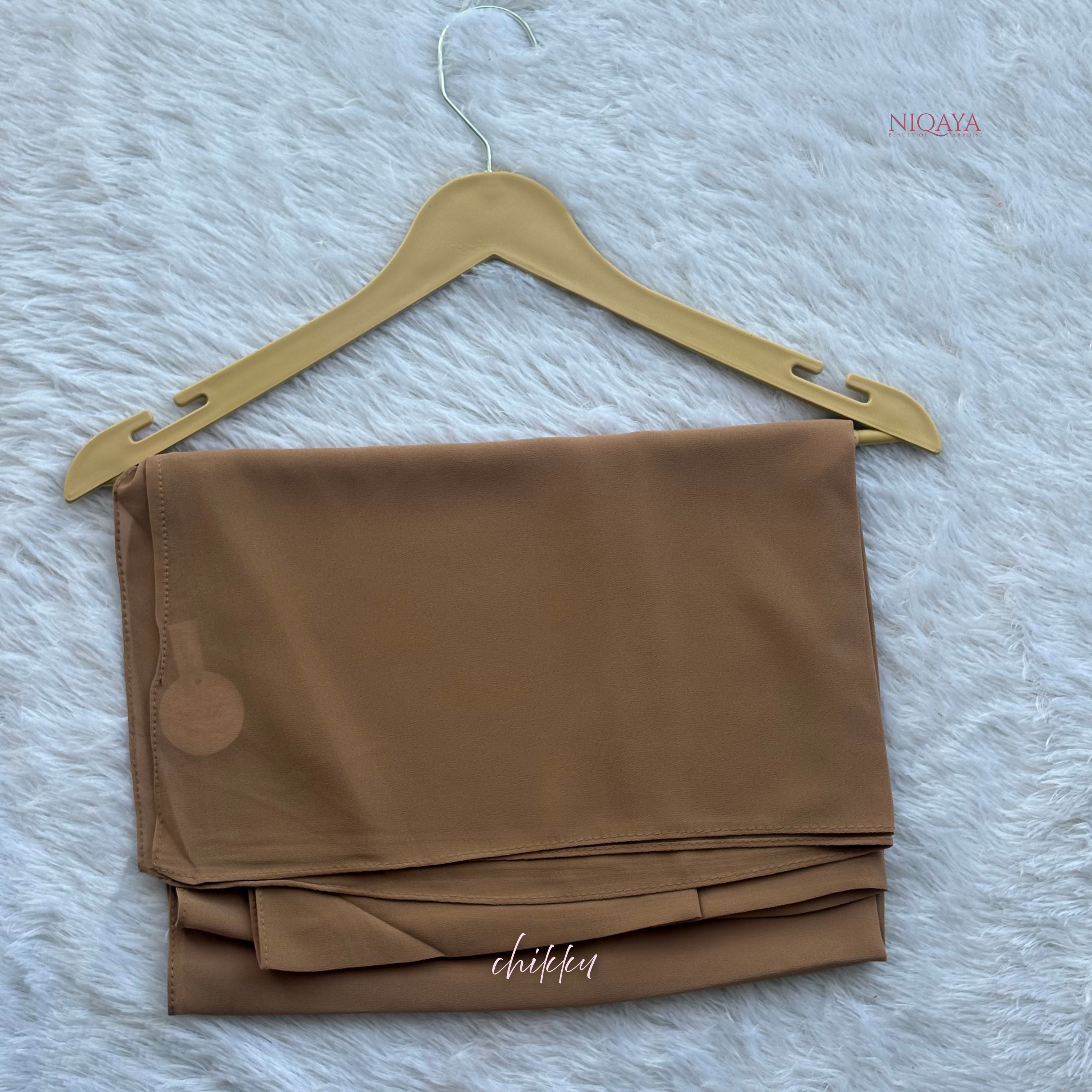 Brown fabric on a gold hanger against a light gray background