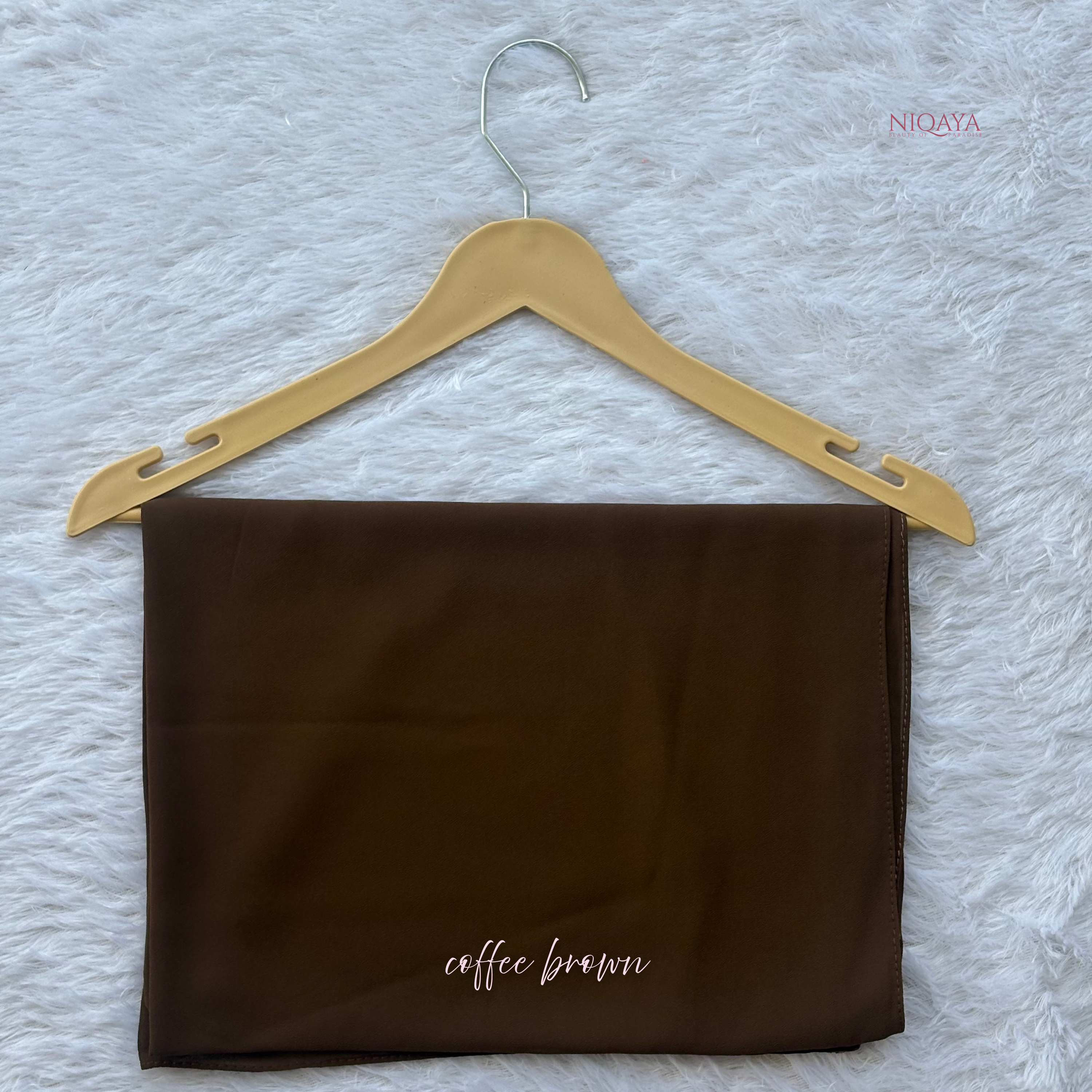 Brown fabric on a hanger with 'coffee brown' text on a textured white background