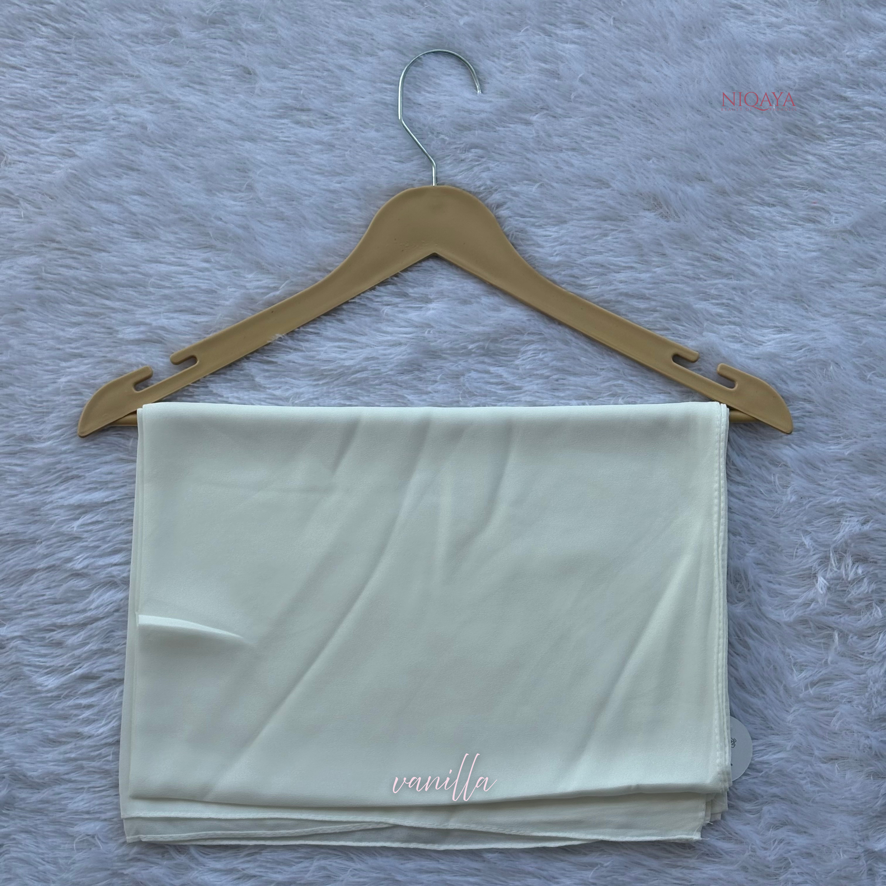 White fabric on a wooden hanger against a textured gray background