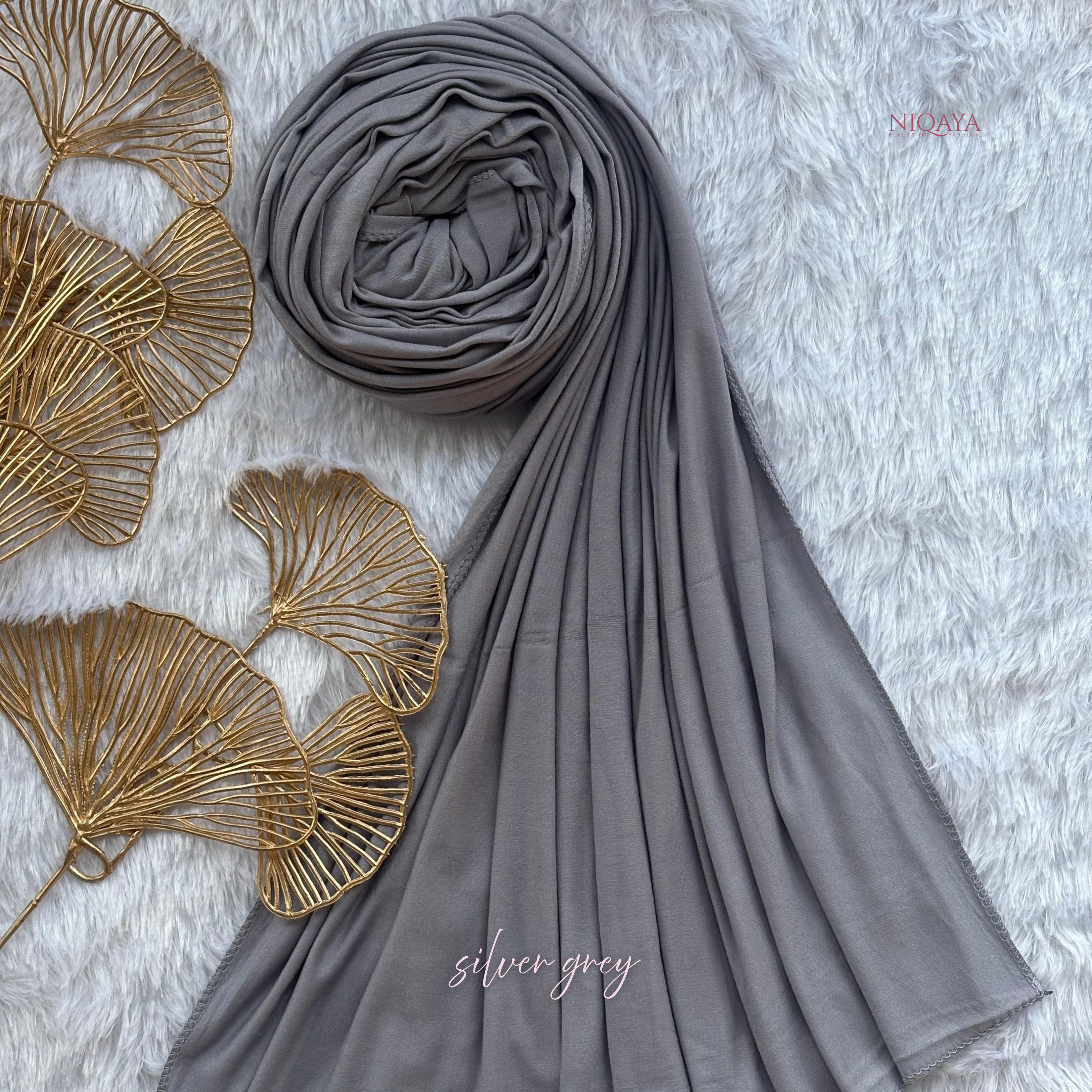 Gray hijab with gold leaf decorations on a textured surface
