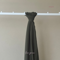 Dark green curtain hanging from a rod against a beige wall with 'Niqaya' branding.