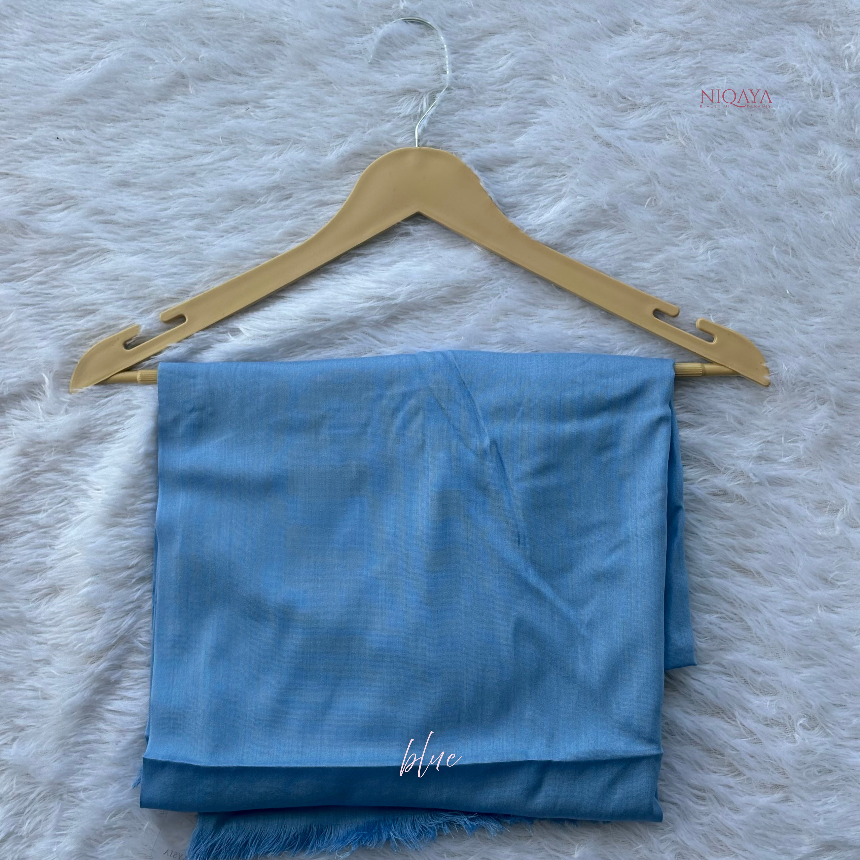 Blue scarf on a gold hanger with 'NIOYA' branding on a textured white background