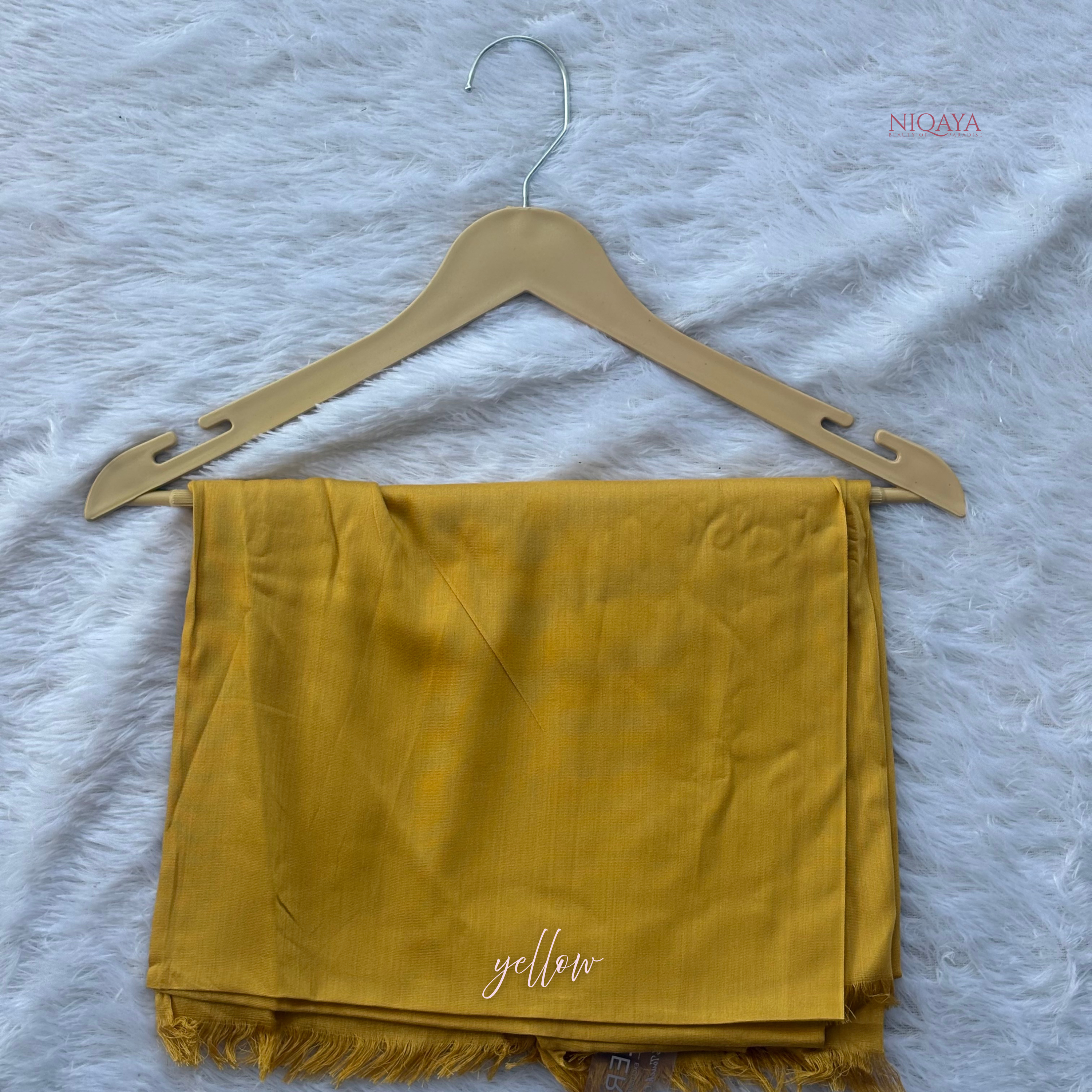 Yellow scarf on a beige hanger with 'yellow' text on a white textured background